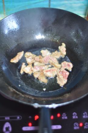 锅里倒入油，油稍热时，将肉放进去用筷子挑散。