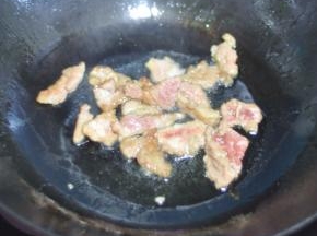 锅里倒入油，油稍热时，将肉放进去用筷子挑散。