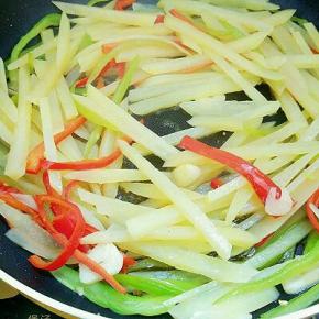 倒入土豆丝翻炒，调入盐、酱油、蚝油、鸡精、白醋和胡椒粉翻炒均匀即可出锅。