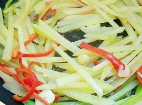 倒入土豆丝翻炒，调入盐、酱油、蚝油、鸡精、白醋和胡椒粉翻炒均匀即可出锅。