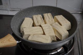 转中火，将豆腐有馅的一面朝下，一块块放在锅里