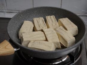 转中火，将豆腐有馅的一面朝下，一块块放在锅里