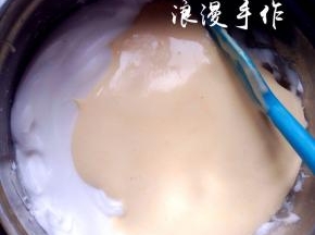 翻拌均匀后把蛋黄糊全部倒入蛋白中，继续翻拌均匀