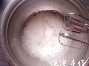 泡沫细腻时再加入1/3的细砂糖打发