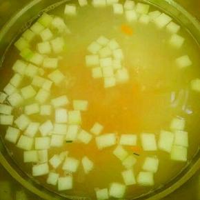 锅里水开放入洗净的大米，以大火煮开后转小火煮5分钟，接着放入胡萝卜和冬瓜煮10分钟，煮至大米开花快熟。（期间要搅动以防粘锅）