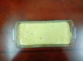 将拌好的南瓜面糊从高处到入法焙客玻璃磅蛋糕模具中，稍微震一下