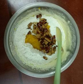 将南瓜泥，低筋面粉+泡打粉（过筛），加入打发好的黄油霜中，用刮刀转盆切拌，至均匀无干粉