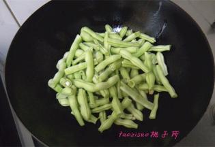 炒锅里倒入食用油，放入蒜瓣炒香，再放入豆角煸炒；