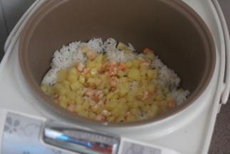 电饭煲剩下的米饭，把土豆虾仁一起放入电饭煲内。