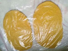 烤箱开始上下管220度预热，把烤盘也一起放进去；面团擀成大约18-20CM长度的长舌状，盖住保鲜膜，醒10分钟
