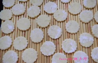 将压好的薯饼坯撒上少许玉米淀粉，放在盖帘上；