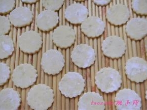 将压好的薯饼坯撒上少许玉米淀粉，放在盖帘上；