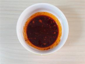 然后加入豆瓣酱一勺。辣椒油一勺。料酒少许。兑成汁。