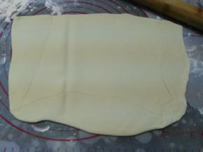 操作台上撒少许高粉防粘，将松弛好的水油皮擀成油酥宽度两倍的长方形，油酥放在1/2处，水油皮面片对折封口捏紧