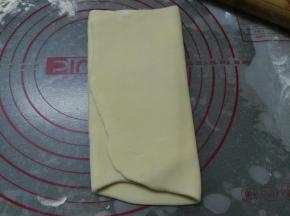 将其稍微擀长，自两端分别向1/3处内折，将面团再次擀长，两端同样分别向1/3处内折，将其再次擀成40*22的长方形面片