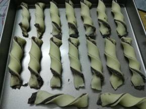 左手固定住面条一端，右手提着另一端扭3-4圈，依次做好摆入烤盘