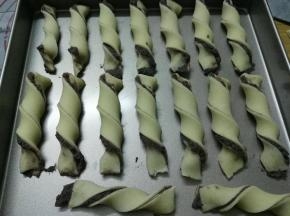 左手固定住面条一端，右手提着另一端扭3-4圈，依次做好摆入烤盘