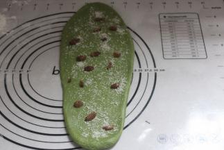 取一份排气擀出舌形，铺上葡萄干和椰丝。