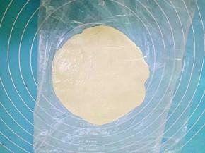 取一份蒸好的面皮，下面铺层保鲜膜，把面皮放在中间，上面在盖一层保鲜膜，擀成圆皮