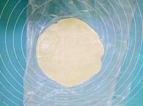 取一份蒸好的面皮，下面铺层保鲜膜，把面皮放在中间，上面在盖一层保鲜膜，擀成圆皮