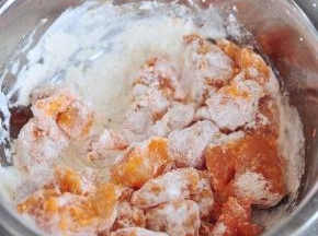 将腌好的鸡块放入炸粉中，将每个鸡块上面，都要裹上一层炸粉。