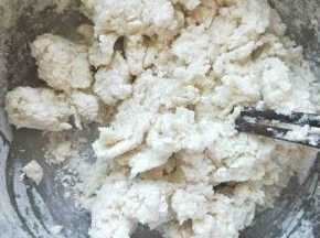 白面放入盆中，然后把开水一点点加入到面粉里，边加边用筷子搅拌成雪花状