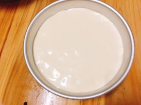 将蛋糕糊倒入模具内，从上往下轻摔几下，振去气泡