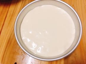 将蛋糕糊倒入模具内，从上往下轻摔几下，振去气泡