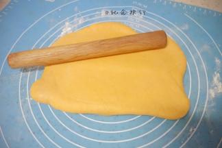 3、揉面垫稍微撒一些干粉，将面团擀成长方形卷起来，再擀开一直反复把面团擀几次
