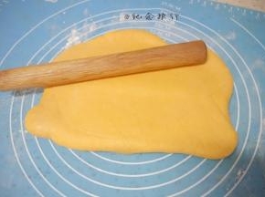 3、揉面垫稍微撒一些干粉，将面团擀成长方形卷起来，再擀开一直反复把面团擀几次

