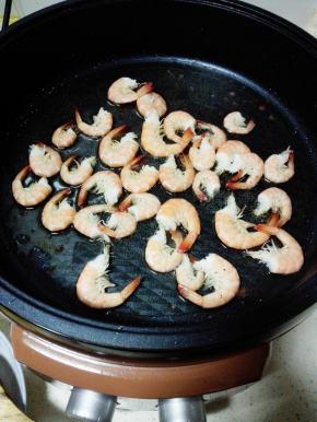 基围虾放入锅中，撒少许盐，煎至壳肉分离即可取出备用