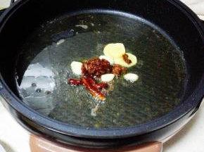 煎烤机内放入两大勺玉米油，烧热后，放入辣椒，花椒，郫县豆瓣酱，姜，蒜，芹菜翻炒出香味