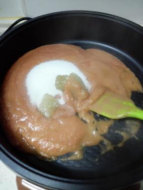 将山楂糊倒入煎烤机中，加入细砂糖和冰糖，中小火炒制