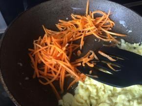 待鸡蛋都结块后，滑一边，放入胡萝卜，翻炒；
