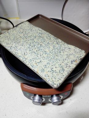 将拌好的糖团放入烤盘内，压平整