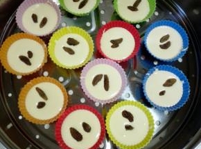 将蛋糕糊倒入硅胶模具中，约20克，7分满，每个模具内放少许葡萄干（没有可不加）