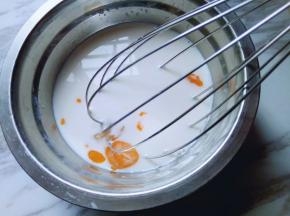 取一个大口容器，加入纯牛奶，鸡蛋敲再里面，手动打蛋器打散。