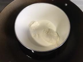 牛奶和奶油奶酪倒入碗里隔水加热。烤箱上下火140度预热。