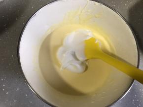 将冷藏的芝士糊取出，取三分之一蛋白霜至蛋黄糊，用翻拌的手法翻拌均匀。切记不要划圈以免消泡。