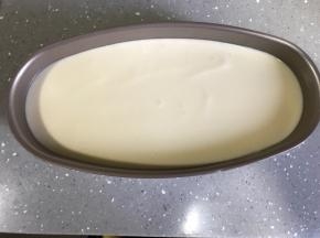 蛋糕糊倒入模具78分满。轻轻晃动模具，使蛋糕糊表面均匀。