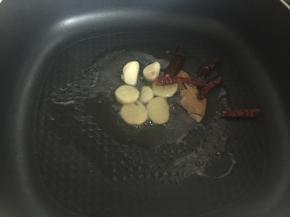 热锅后，锅里倒入适量油，放入姜片、蒜瓣、香叶、干红辣椒爆香