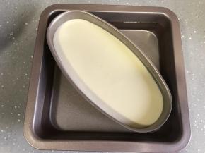 取一个烤盘倒入温水，芝士模具放入烤盘，水没过模具一半左右。烤盘放入烤箱底层，将温度调至上下火130度烤90分钟。