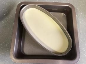 取一个烤盘倒入温水，芝士模具放入烤盘，水没过模具一半左右。烤盘放入烤箱底层，将温度调至上下火130度烤90分钟。