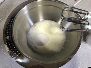 开动打蛋器低速将蛋清打至粗泡状态，一次性加入细砂糖，继续高速打发至湿性发泡。