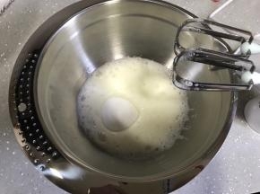 开动打蛋器低速将蛋清打至粗泡状态，一次性加入细砂糖，继续高速打发至湿性发泡。