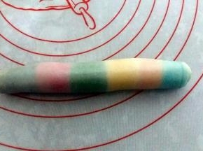 由上至下卷起，收口朝下，盖上保鲜膜，松驰10~15分钟；。