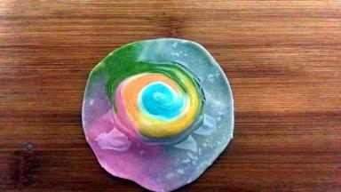 用擀面杖将边缘擀薄，不要擀中间的螺旋纹。