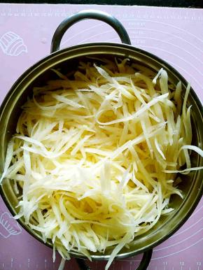 土豆擦成丝，多过几遍清水，去掉里面的淀粉，放在漏网上沥水备用。