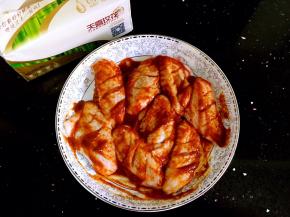 鸡翅中倒入香辣烤酱揉搓均匀。放入冰箱冷藏两个小时方便更好的入味。