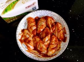 鸡翅中倒入香辣烤酱揉搓均匀。放入冰箱冷藏两个小时方便更好的入味。